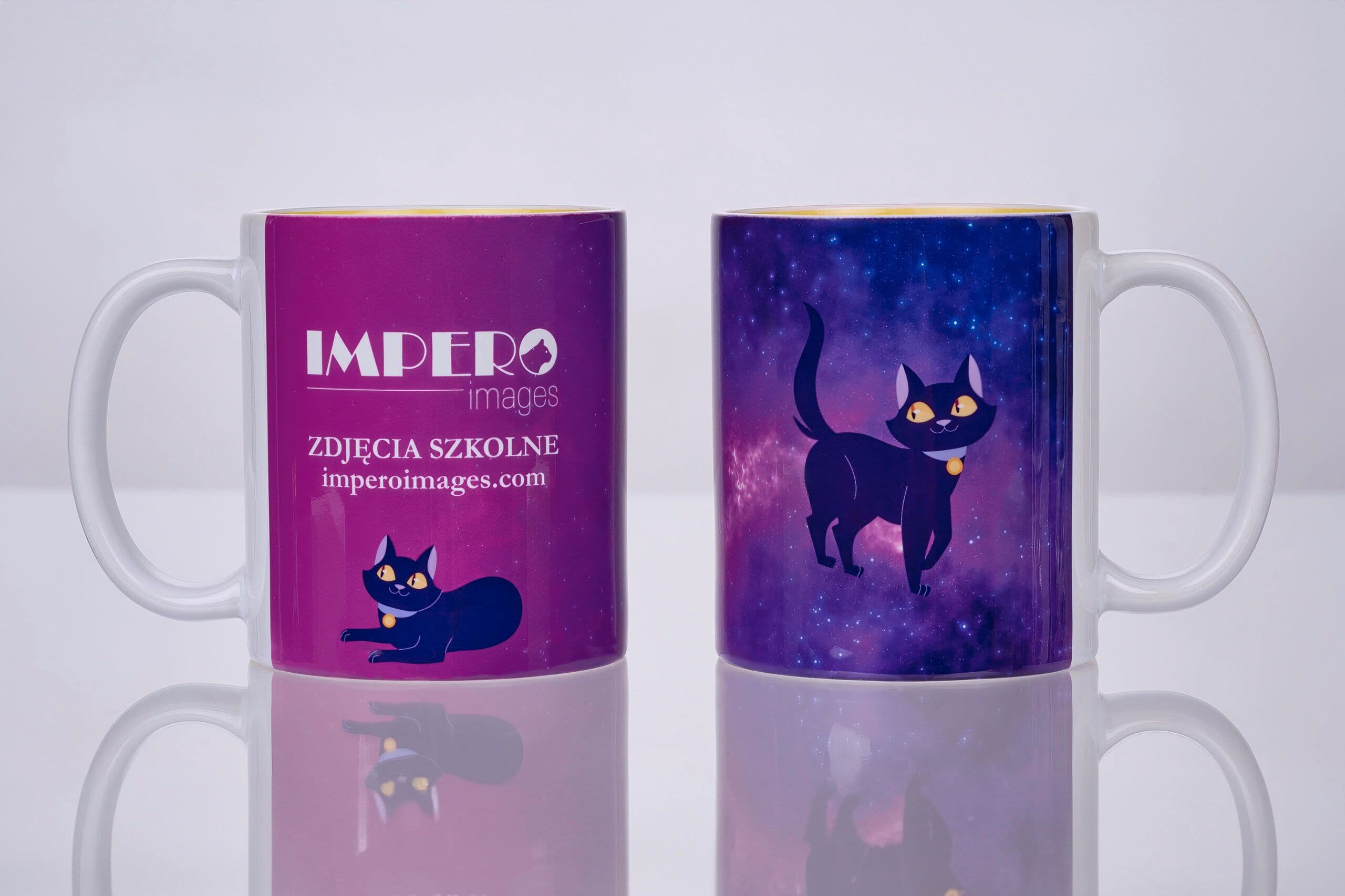 Produkty fotograficzne Impero Images — dwa kubki z motywem kota maskotki i logo firmy na jasnym tle